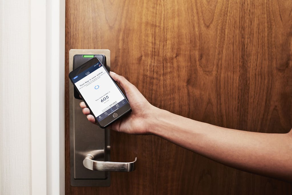 Using the CQ Hotel App on a smartphone to open the guest room door at Club Quarters Hotels