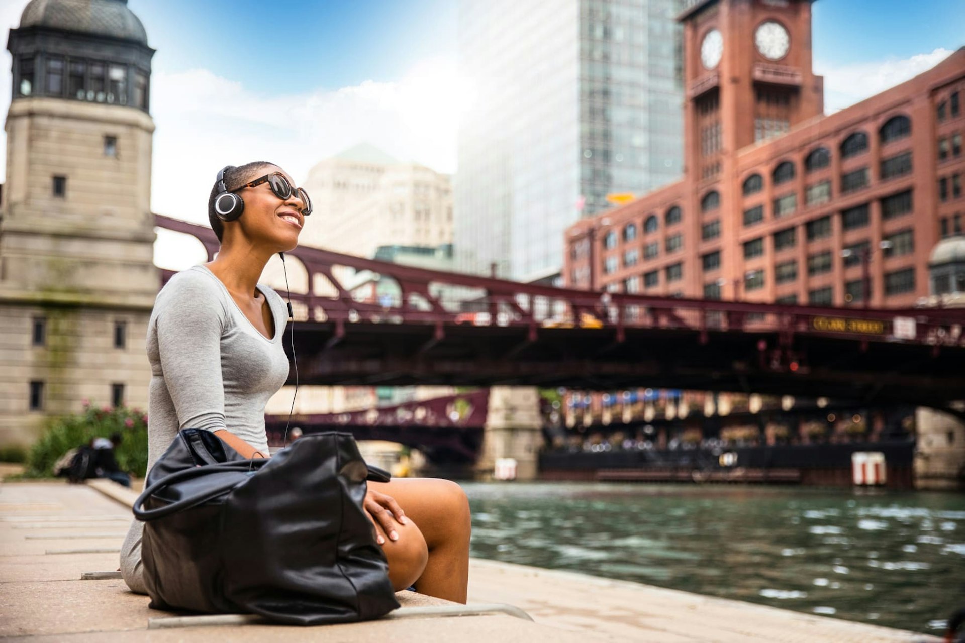 Girl Sitting by River With Headphones in Chicago