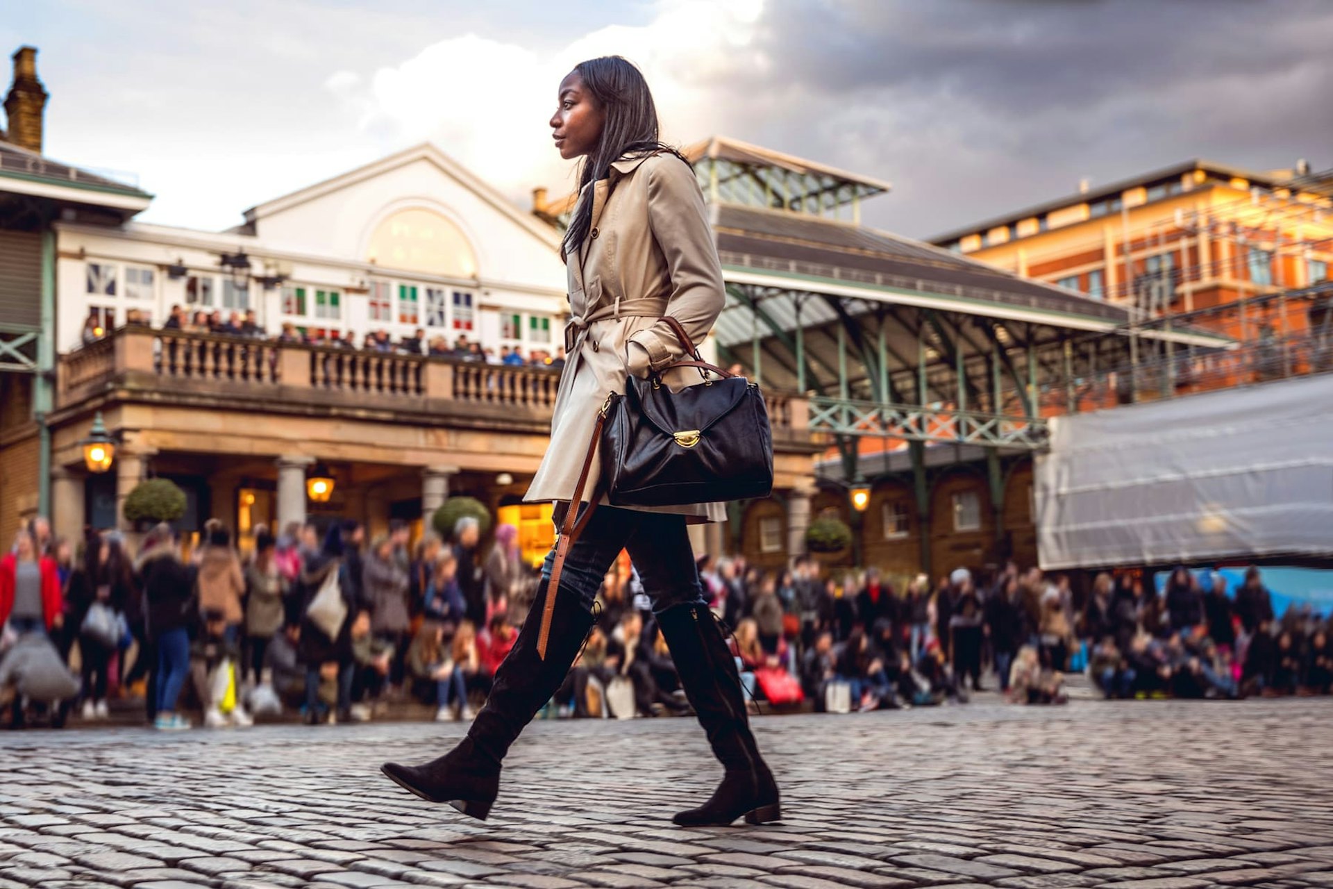 Woman walking past a market, London