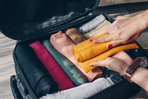 Rolled clothes inside of a suitcase packed for a business trip.